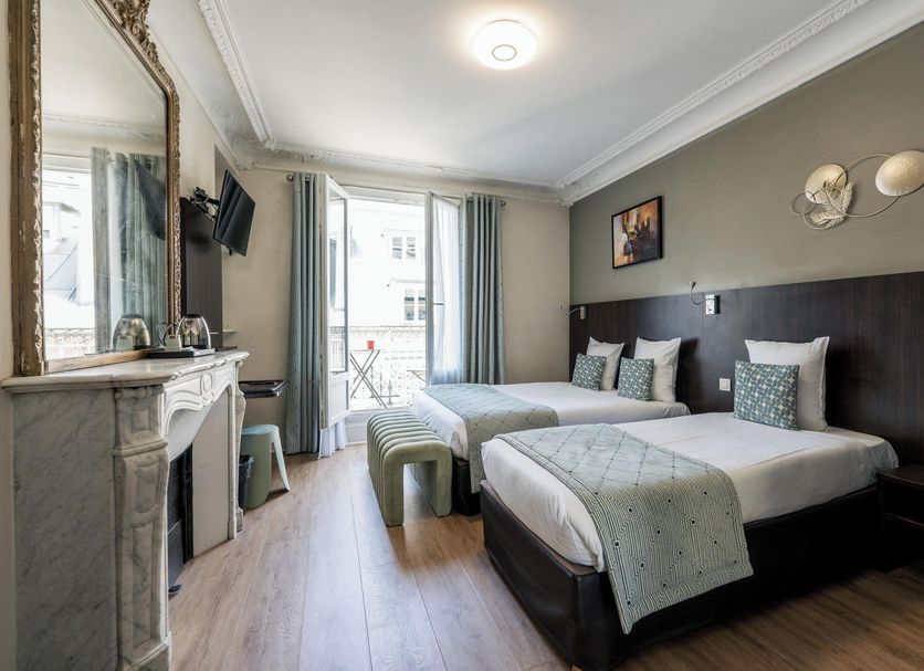 Hotel Corona -Rodier- Paris guest room with two twin beds, fireplace, and French doors to balcony