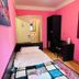 L'Affittacamere di Venezia in Venice, a bright pink guest room with single bed, desk, mirror and wardrobe.