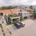 Isabella Boutique Hotel in San Pedro Sula with red-roofed building and parked cars