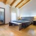 Hotel La Pergola in Lignano Sabbiadoro guest room with double bed, bench, wooden ceiling and floor