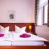 Pension an der Pillnitzer Schlossfähre, Dresden: twin beds with purple towels in a simple guest room