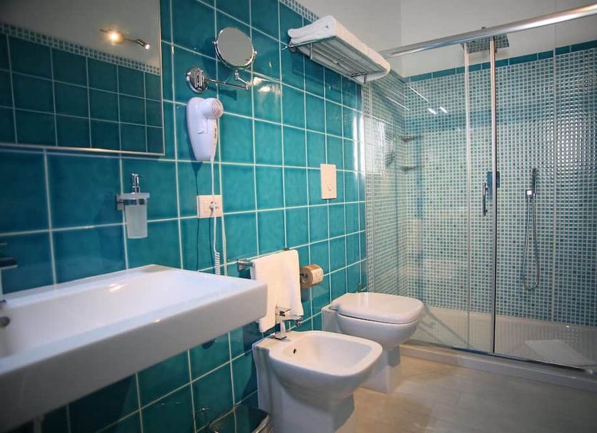 Hotel Regina Simius bathroom with shower, bidet and wall-mounted sink in Villasimius