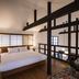Rinn Shiki Juraku Kyoto guest room with king bed, loft railing, and black hanging chair