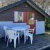 Grindsted Aktiv Camping cabin with deck, white chairs and table in Grindsted
