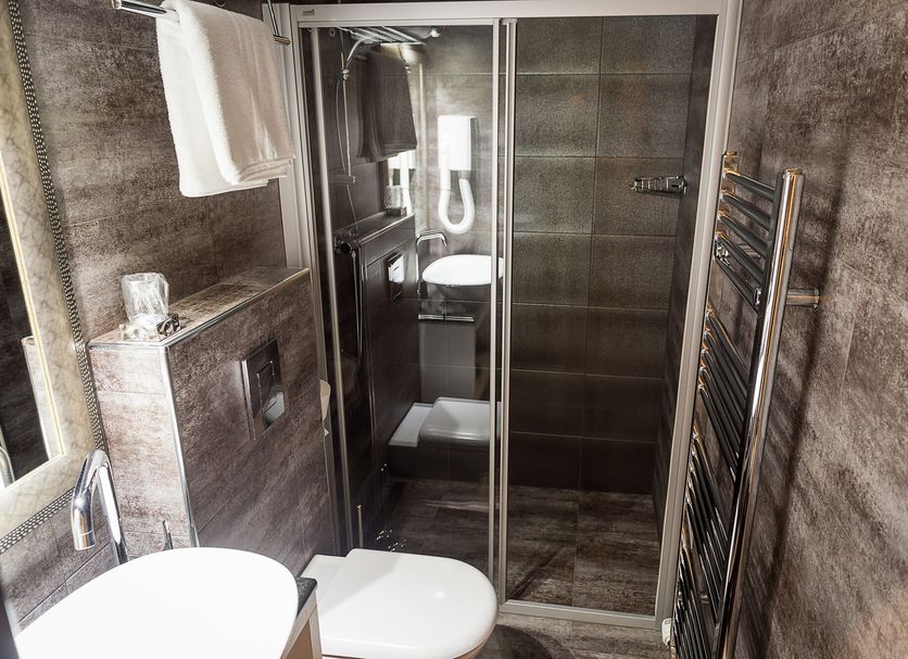 Log In Rooms Zagreb 4-star bathroom with glass shower, toilet, sink, and towel rack