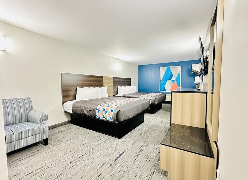 Northland Motel Sudbury room with two beds, armchair, TV, and blue accent wall