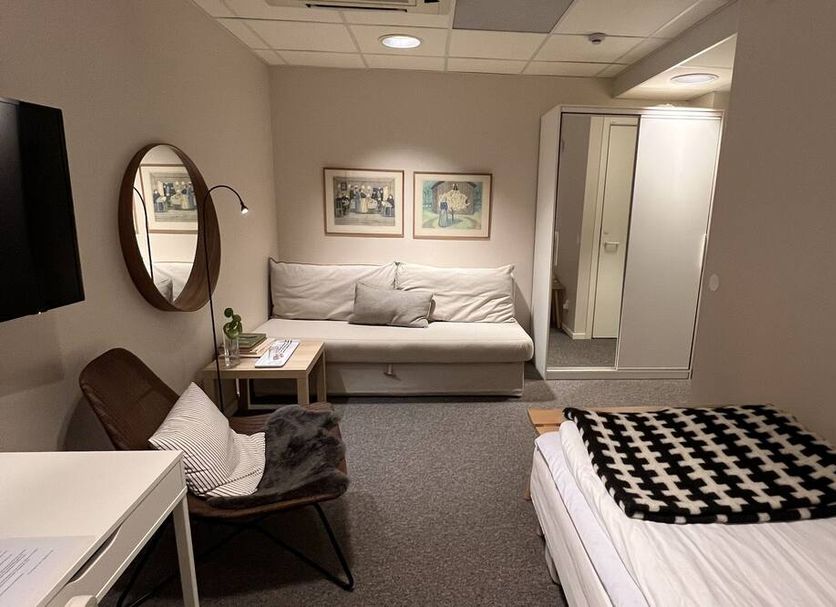 Hotell Garvaren in Ljungby guest room with sofa bed, single bed, wall TV and wardrobe