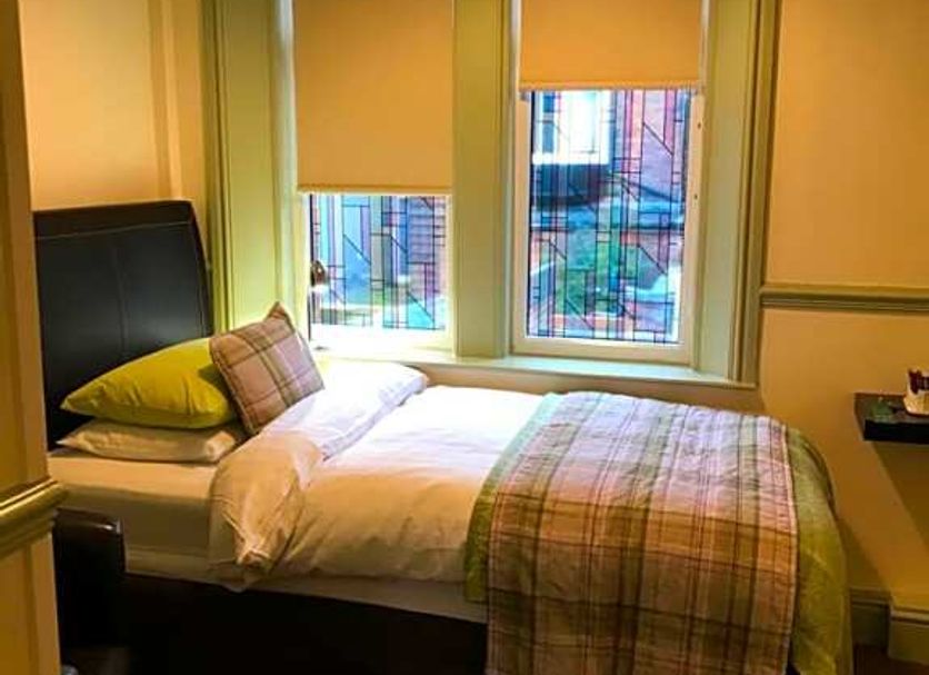 Abberley House in Carlisle guest room with single bed beside twin windows and blinds