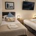 Dolgun Uchaf Guesthouse in Dolgellau twin room with two beds, bedside lamps, and wall-mounted TV