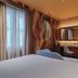 WorldHotel Casati 18 Milan guest room with bed, desk, chair, and abstract mural
