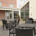 Ramada by Wyndham Wakefield in Ossett patio with wicker tables and chairs beside glass entrance