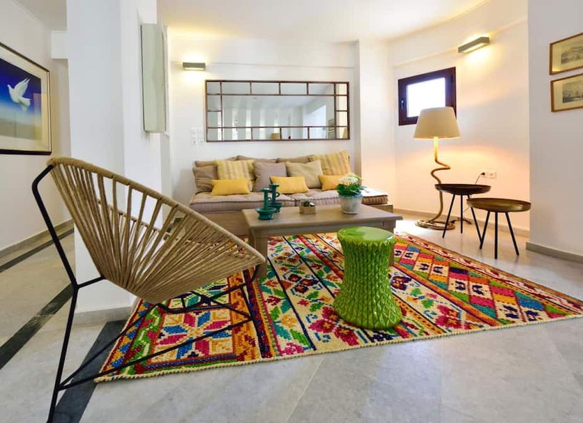 Kalidon Beach Hotel, Kokkari: bright lounge with colorful rug, woven chair, sofa and lamp