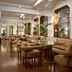 The Danai, Nikiti: elegant lounge with tan seating, glass tables and tall arched windows