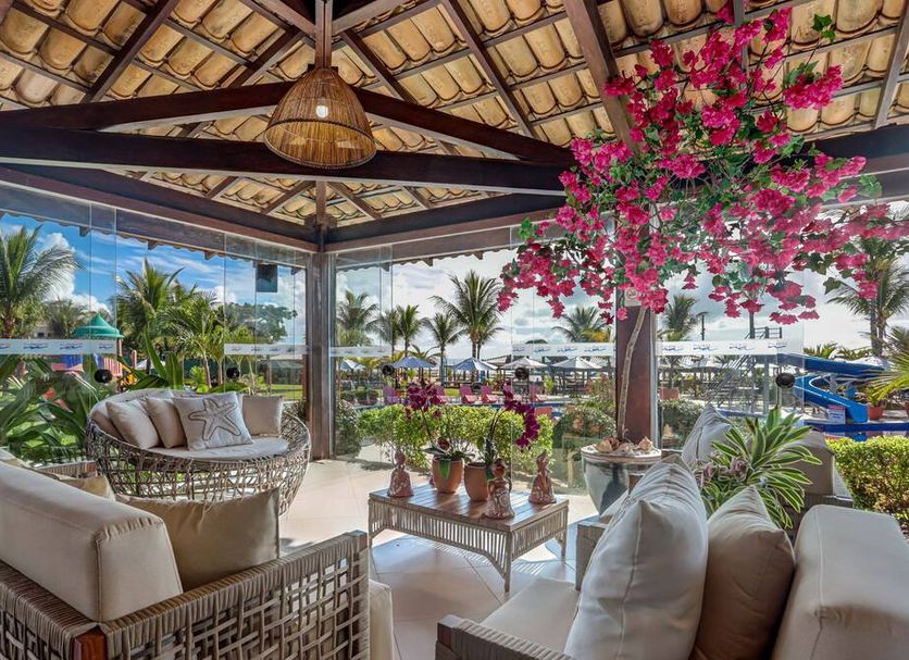 Hotel Praia do Sol in Ilhéus with a tropical open-air lounge, flowers, and palm garden views