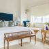 Gardiner House in Newport guest room with king bed, teal headboard, bench, and window seat