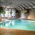 Indoor pool at The Woodlands Inn in Wilkes-Barre with lounge chairs and hanging plants