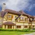 Hotel Le Renard in Campos do Jordão, alpine-style facade with stone chimney and manicured lawn