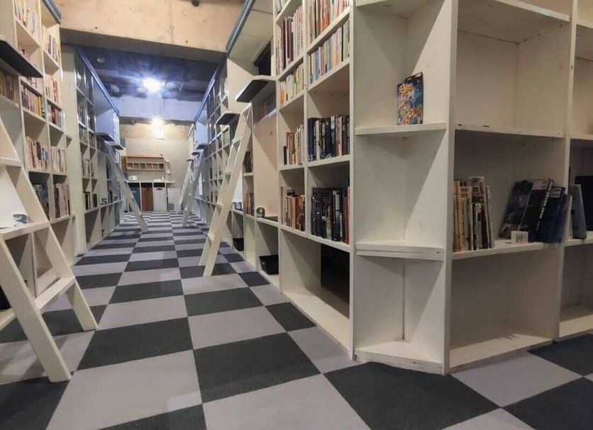 bnbplus Niigata Book Inn in Niigata, library-style hallway with bookshelves and checkered floor