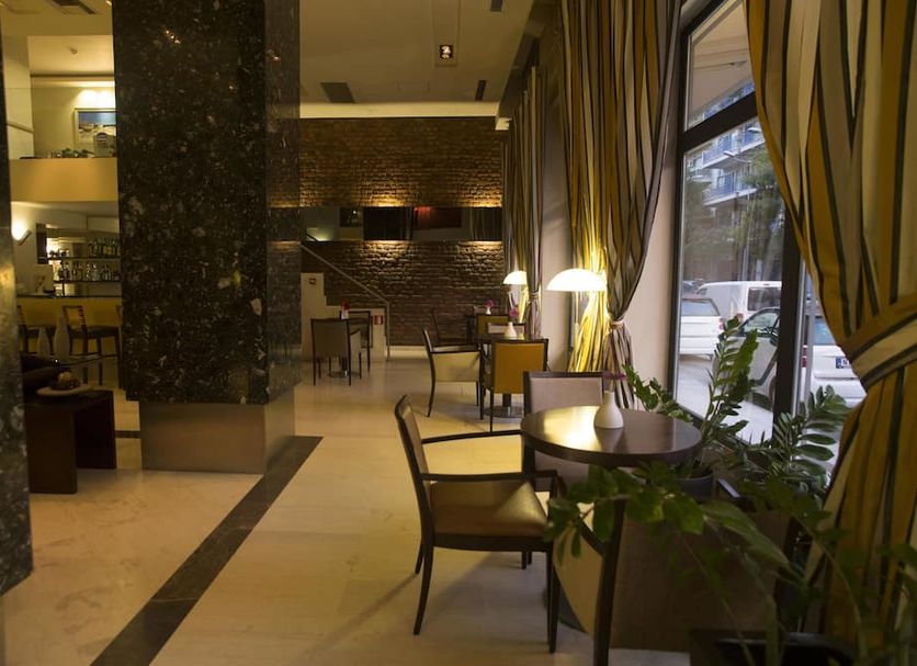 Davitel - Tobacco Hotel Thessaloniki lounge with tables, chairs, marble columns and tall windows