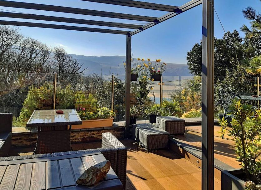 Bryn Melyn Apartments in Barmouth terrace with outdoor seating and mountain and water views