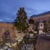 Relais & Châteaux Heritage Hotel Madrid rooftop terrace with wrought-iron tables, chairs, and potted plants at dusk