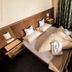 Pension Kreuzjoch in Zell am Ziller bedroom with double bed, pillows, bedside tables and curtains