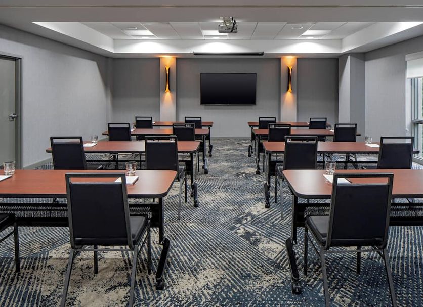 Hyatt Place Fair Lawn Paramus meeting room with conference tables, chairs, and wall-mounted screen