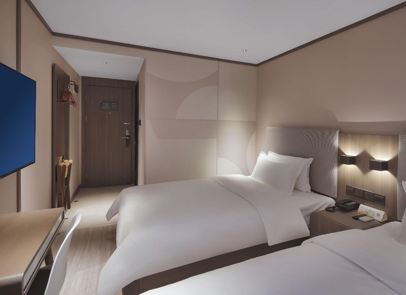 Hanting Hotel Nanjing Hunan Road guest room with two beds and wall lights in Nanjing
