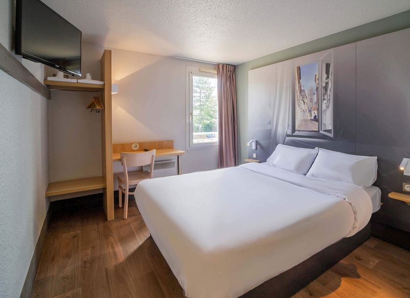B&B HOTEL Saint-Quentin compact guest room with double bed, desk, TV, and window in Saint-Quentin