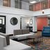 Hampton Inn Russellville lobby with blue chairs, sofa, round tables and mezzanine balcony