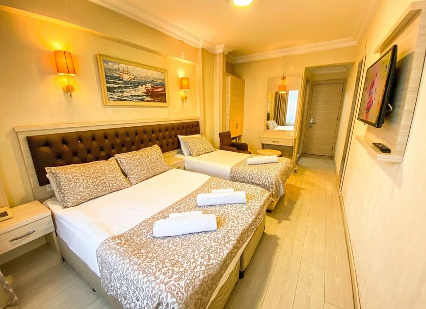 Mekke Hotel Istanbul guest room with two single beds and wall-mounted TV in Istanbul