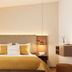 Galerie Hotel Bad Reichenhall guest room with king bed, mustard bedding and bedside lamps