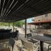 Kaiafas Lake Hotel in Zacháro: shaded outdoor patio with tables, chairs and a pool view