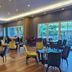 d'primahotel Kualanamu Medan dining area with tables, chairs, wood floors and large windows in Medan