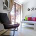 Flora Daisy Apartment in Borovets with black lounge chair, sofa, and balcony door