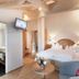 Landhotel Föhrenhof Ellmau guest room with king bed, seating area and open bathroom doorway in Ellmau