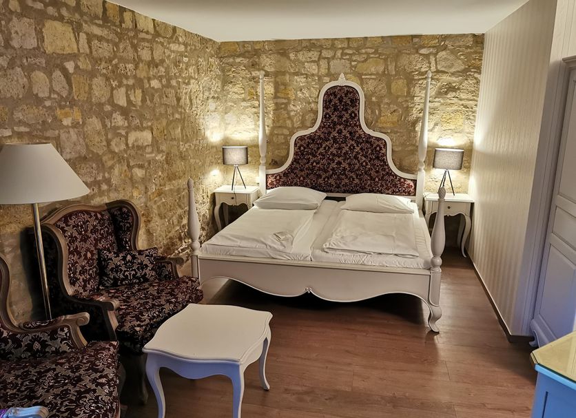 Hotel & Spa Wasserschloss Westerburg guest room in Huy with stone walls and ornate bed