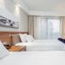 Hampton by Hilton Oswiecim room with two beds, desk, TV and window curtains in Oświęcim