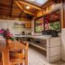 Cabañas La Pradera in Monteverde: rustic cabin kitchen and dining area with wood-paneled walls and skylight