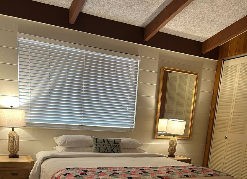 Tropical Resort & Marina on Lake Beresford room with bed, bedside lamps and window blinds in DeLand