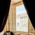 Riad Dar Ayur Marrakech seating nook by a large lattice window with dark curtains and a small table