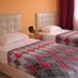 Gultepe Apartments in Kusadasi twin bedroom with two single beds, patterned blankets and window light