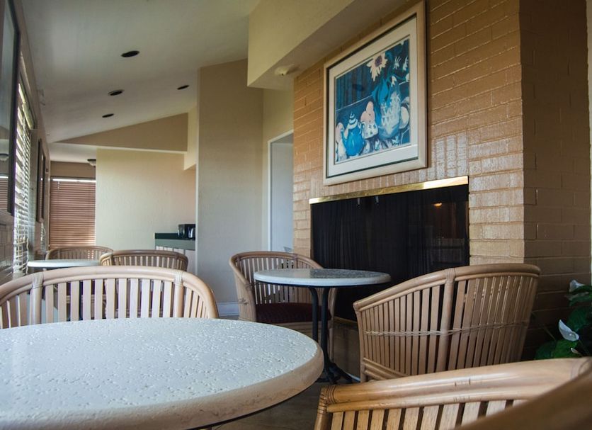 America's Inn Houston/Stafford/Sugarland lounge with wicker seating and fireplace in Houston