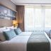 Leonardo Royal Hotel Düsseldorf Königsallee guest room with twin beds, desk, and large window in Düsseldorf