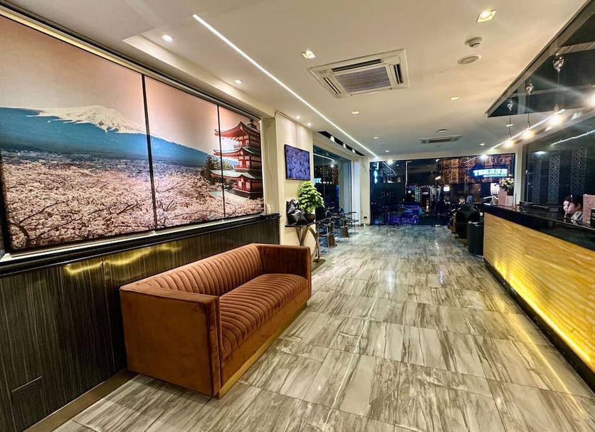 Sakura Sky Residence Bangkok lobby with reception desk, seating area and beach wall art