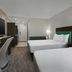 Home2 Suites by Hilton Anchorage/Midtown guest room with two beds, desk, TV, and hallway view