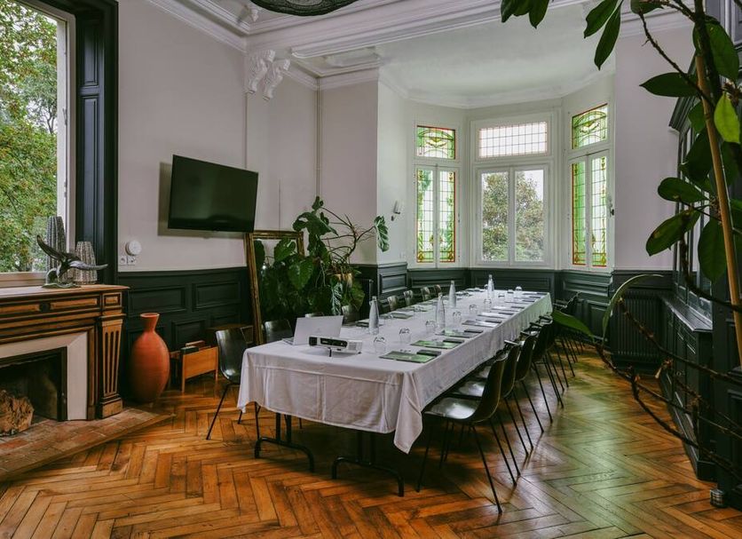 Le Château des Forges in Angers dining room with long set table, bay windows, fireplace and garden view