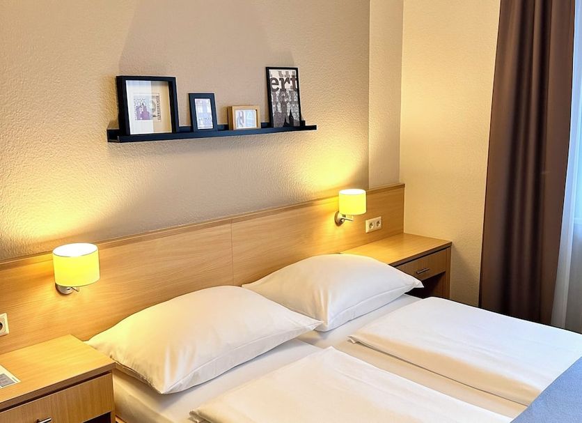 Hotel Friedrichstraße, Lampertheim: bright twin room with bedside lamps and window curtains