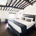 Youroom Corsini Rome guest room with king bed, exposed beams and dark wood floor