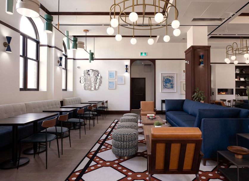 The Postmark Hotel in Newmarket lobby lounge with blue sofa, tables, and modern hanging lights